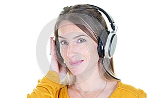 Happy blonde girl listening music in headphones on white background