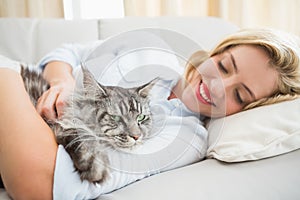 Happy blonde with pet cat on sofa