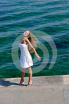 Happy blonde in white near sea on pier