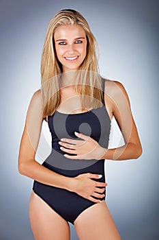 Happy blonde woman in black swimsuit