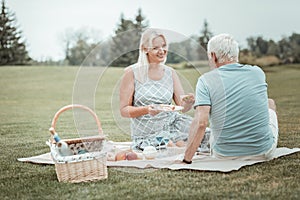 Happy blonde woman giving sandwich to her partner