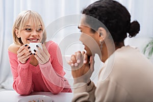 happy blonde woman holding cup and