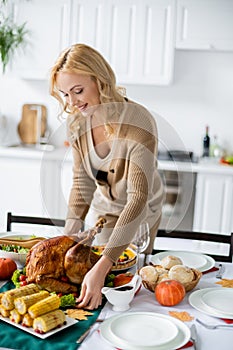 happy blonde woman serving table with