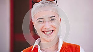 Happy Blonde Young Girl Looking at Camera. Close Up Portrait of woman laughing and smiling outdoors