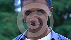 Happy blue-haired black male teen smiling on camera, self-confidence, expression