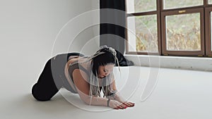 Happy body positive fat woman with dreadlocks doing yoga in the gym. Concept of natural diverse beauty and sport