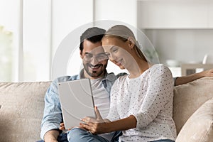 Happy young family couple using digital computer tablet.