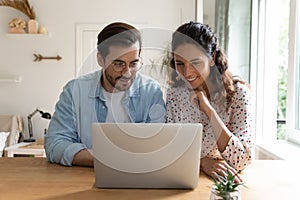 Happy bonding family couple using computer at home.