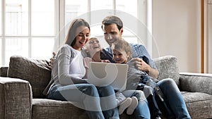 Happy bonding family enjoying watching funny comedian movie on laptop.