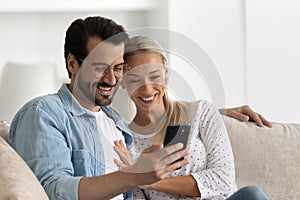 Happy bonding family couple using cellphone at home.