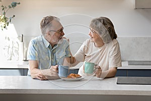 Happy bonding middle aged family couple eating breakfast.