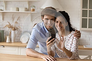 Happy bonding millennial family couple using smartphone.