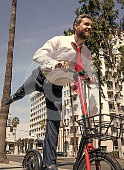 Happy boss in formalwear ride city scooter along sidewalk, scooting photo