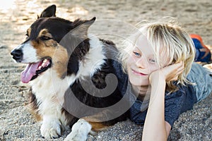 Happy boy with arm around pet dog