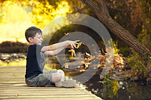 Happy Boy with autumn leaves in beauty park park