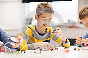 Happy boy building robot at robotics school