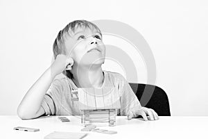 Happy boy building small wooden house. Childhood dreams. Little boy builds his dream house. House or mortgage investment concept.