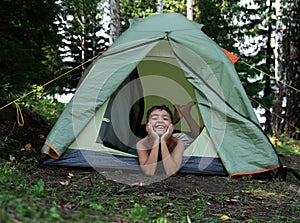 Happy boy in camping tent