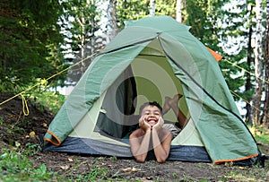 Contento ragazzo campeggio una tenda 