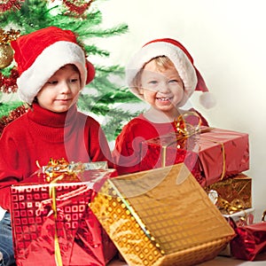 Happy boy with christmas gift near Christmas tree