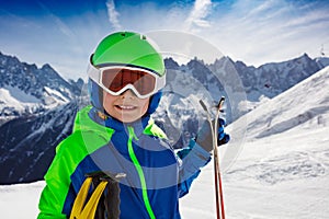 Happy boy close portrait with ski over mountains