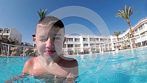 Happy Boy with a Comic Face Takes a Video of Himself on Selfie Camera in Water Pool.