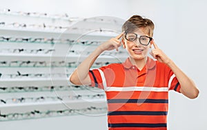 happy boy in crooked glasses at optics store