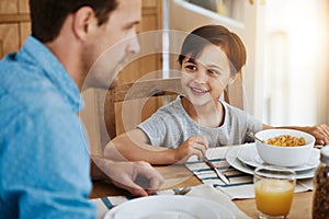 Happy, boy and dad together with breakfast on table for nutrition and eating or sharing. Hungry, man and kid in home