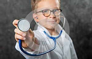 Happy boy in doctor costume holding sthetoscope