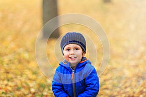 Happy boy dressed in warm clothes with hat and coat in blue colo