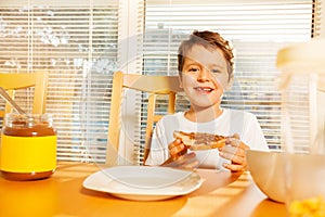 Happy boy eating toast with chocolate spread