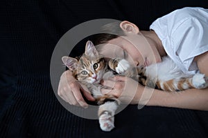 Happy boy embracing young kurilian bobtail kitten with love