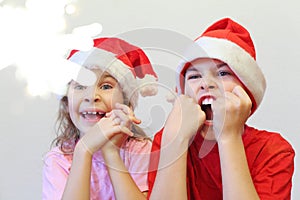 Happy boy and girl in Christmas red caps