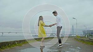 Happy boy and girl dance emotionally some joyful jive on a pier on a sea coast