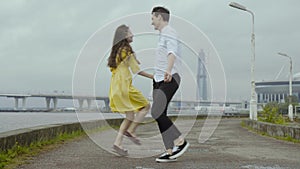 Happy boy and girl dance happily some speedy boogie on a pier on a sea coast