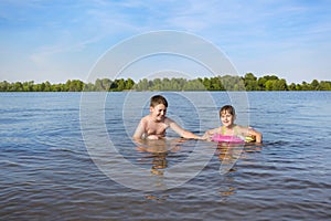 Happy boy and girl play in the water.  Summer holidays.  Children  have  fun  outdoors