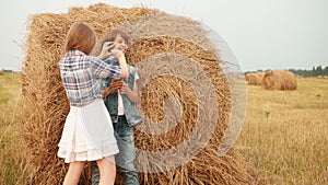 Happy boy and girl playing on haystack in field