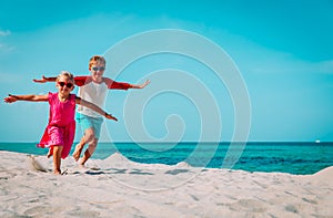 Happy boy and girl run play at beach