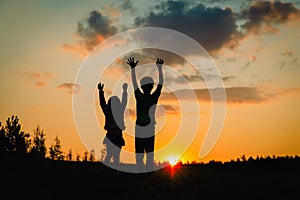 Happy boy and girl silhouettes enjoy sunset nature