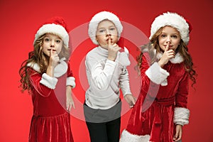 The happy boy and girls in santa claus hats with gift boxes at studio