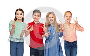 Happy boy and girls showing peace hand sign