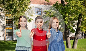 Happy boy and girls showing thumbs up