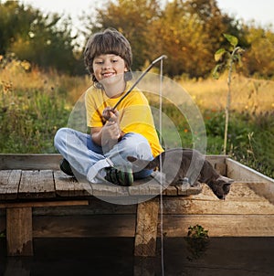 Happy boy go fishing on the river, one child of the fisherman with a fishing rod on the shore of lake