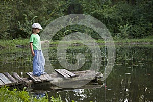 Happy boy go fishing on the river, one children fisherman with a