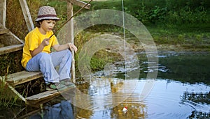 Happy boy go fishing on the river, one children fisherman with a