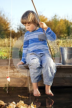 Happy boy go fishing on river, one children fisherman with a