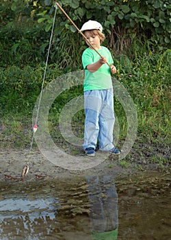 Happy boy go fishing on the river, one children fisherman with a