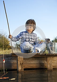 Happy boy go fishing on the river with pet, one children and kit