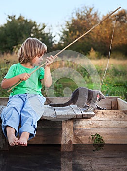 Happy boy go fishing on the river with pet, one children and kit