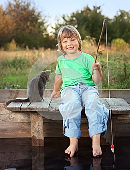 Happy boy go fishing on the river with pet, one children and kit